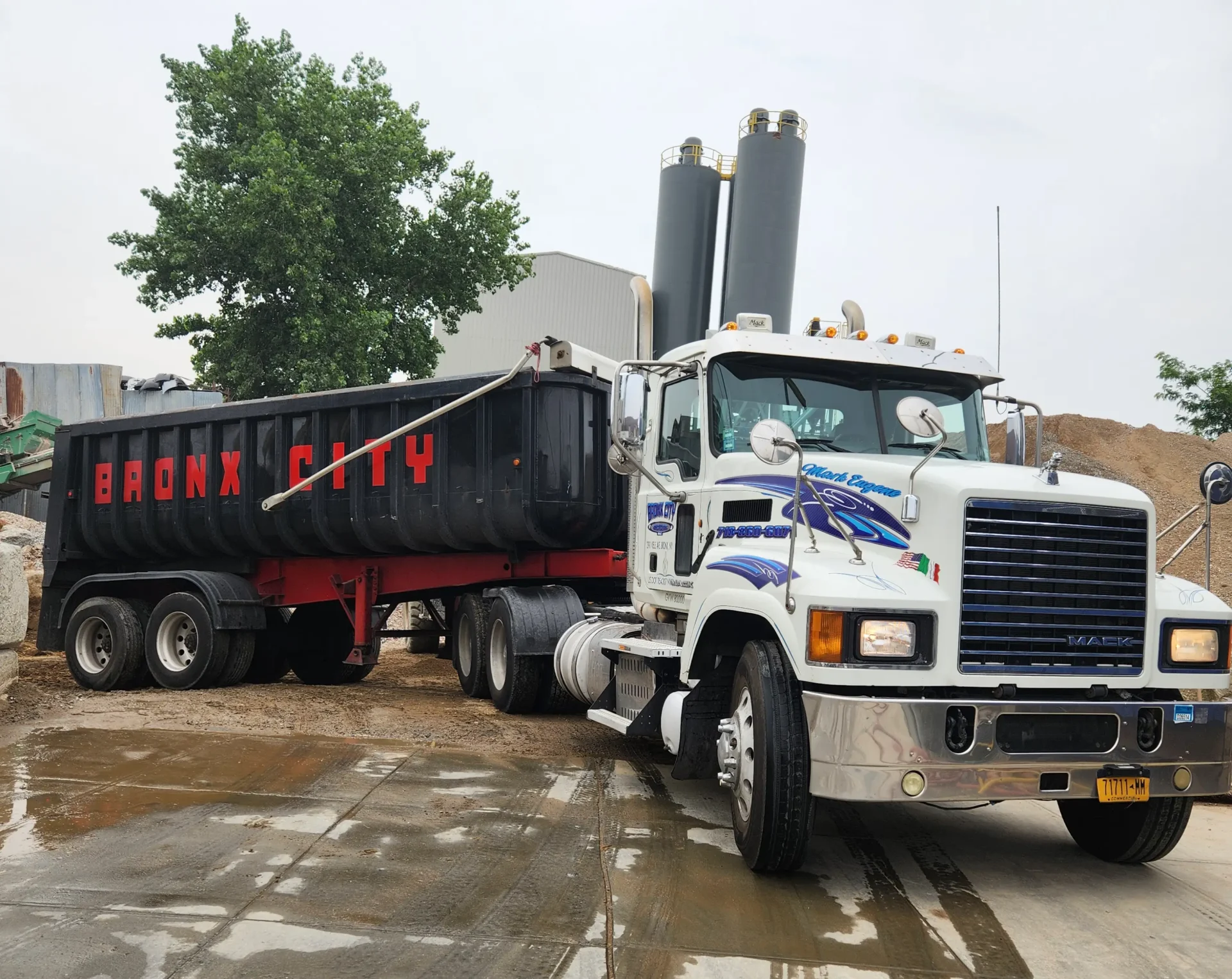 A large truck is parked next to a trailer.